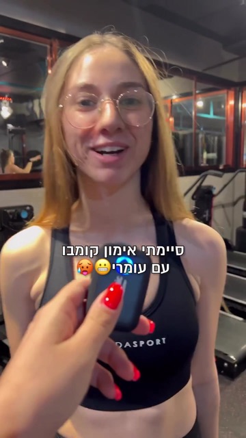 צעירה עם משקפיים מרואיינת עם מיקרופון בחדר כושר, קאבר רילס עם הכיתוב "סיימתי אימון קומבו עם עומרי"