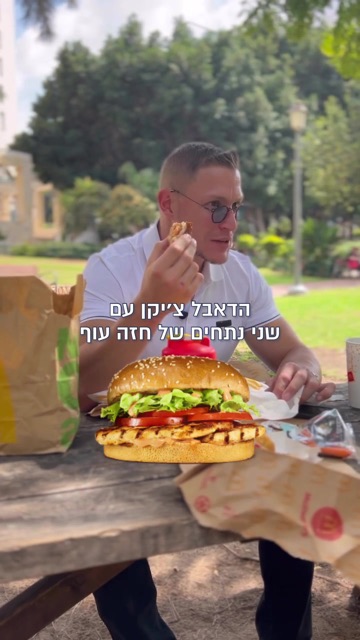 גבר אוכל המבורגר עוף גדול בפיקניק בפארק, קאבר רילס - "הדאבל צ'יקן עם שני נתחים של חזה עוף"